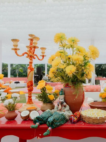 A close-up of a table centerpiece from our 'Haldi Holi' event. We even sprinkled some of the holi colors onto the flowers themselves, a fun little detail that tied everything together perfectly.