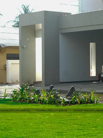 A wide, open lawn provides a clean and calming counterpoint to the modern architecture of the home and the sculptural water feature.