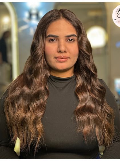 A full-frontal view of the final look, showcasing a happy client with beautiful, healthy-looking hair.