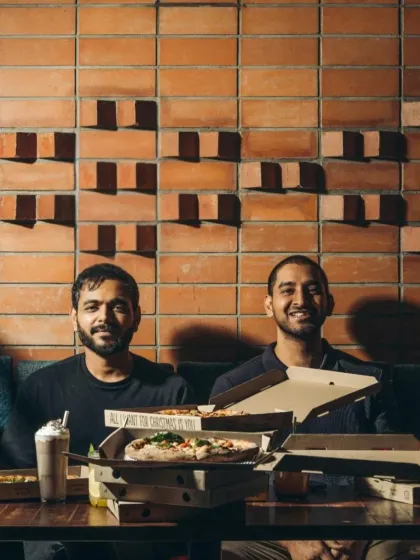 The founders surrounded by pizzas at a Christmas celebration. It's a reflection of the family and community we've built around our brand.