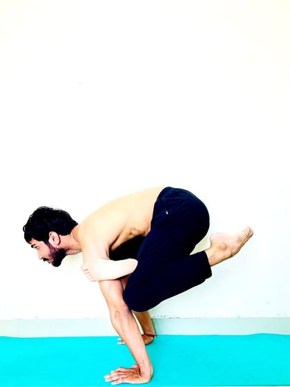 A variation of Bakasana (Crane Pose) with one knee tucked in, a preparatory stage for more advanced arm balances.