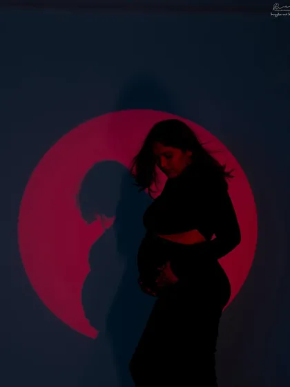 Adding a pop of color with a projected red circle. This creates a bold and dramatic silhouette, perfect for a memorable and artistic maternity photo.