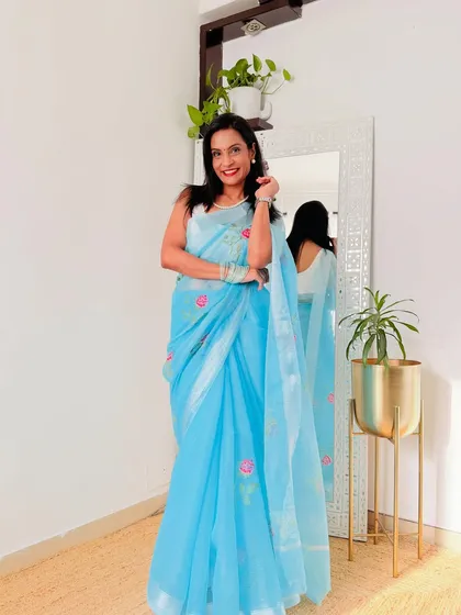 A closer look at a sky blue Kota Doria saree with delicate floral embroidery. The combination of the lightweight fabric and the pretty embroidery is perfect for summer.