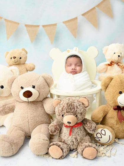 A teddy bear picnic with a very special guest. This little one is surrounded by a crowd of cuddly friends, making for an incredibly cute and heartwarming photo.