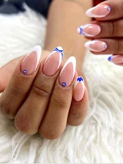 Another view of the evil eye French manicure, showing the full set and the beautiful almond shape of the nails.