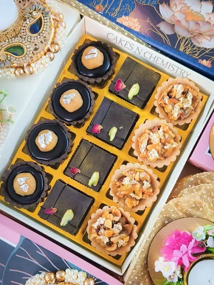 A box of assorted tarts from my Diwali 2023 menu. It includes a mix of chocolate tarts with an Indian twist and crunchy nut tarts, all beautifully arranged in a festive gift box.