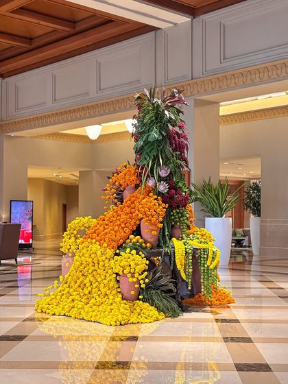 A side profile of the grand floral installation, showing its scale and the intricate way the different flowers and foliage are woven together.