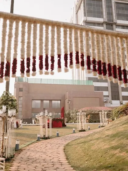 A floral archway made entirely of tuberose strings with a red rose border, creating a fragrant and beautiful entrance.