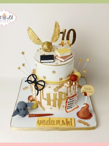 A magical Harry Potter cake for a 10th birthday. This two-tiered design is full of wizarding world details, including the Golden Snitch, Hedwig, a wand, and the Sorting Hat.