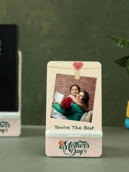 A practical and personal gift for Mother's Day. This custom mobile phone stand holds a device securely while displaying a sweet photo and a "Happy Mother's Day" message.