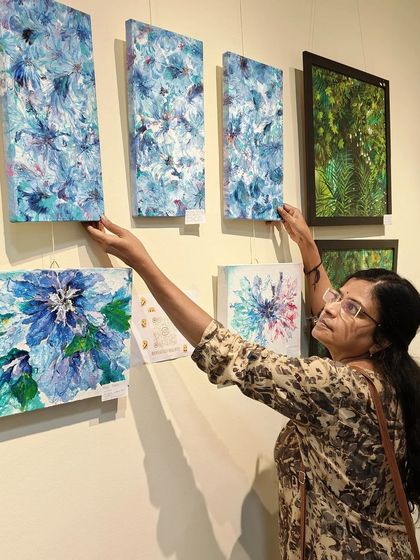 Adjusting my abstract floral paintings on the gallery wall. Getting the display just right is part of the process.