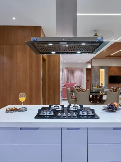 This kitchen island is a true workhorse, featuring a built-in hob, ample drawer storage, and a powerful chimney hood. It opens up to the dining area, making it perfect for entertaining while you cook.