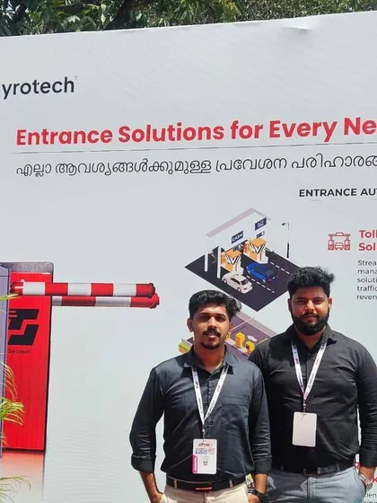 Our team standing proudly beside a banner showcasing our "Entrance Solutions for Every Need" at the Autosec Expo in Kerala. We offer everything from toll management to residential and commercial parking solutions.