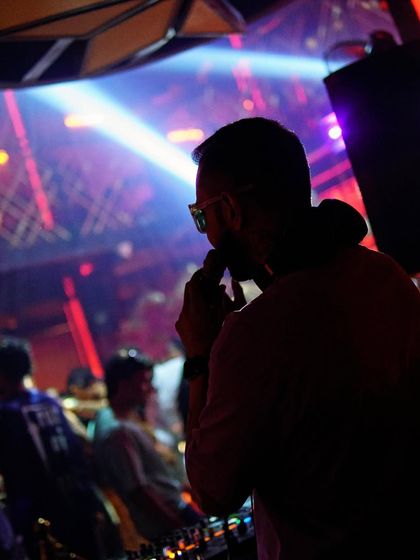 Behind the console, you are my dopamine and I'm yours. A silhouette shot capturing the intimate connection with the crowd.