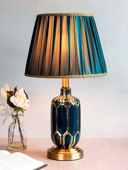 This version of the Crown Royal lamp features a deep teal base with a gold geometric pattern. The matching pleated shade creates a bold, monochromatic look that is both modern and luxurious.