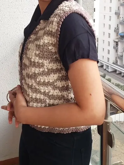 This is the Lisa Vest, a classic V-neck vest with a beautiful textured stitch. The variegated yarn creates a lovely camouflage-like pattern.