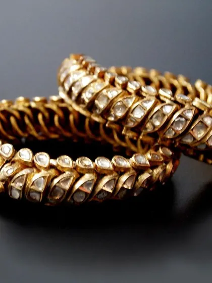 From a royal Maratha collection, this pair of traditional 'Shrankhla Jodi' twisted bangles, circa 1820, exemplifies heritage and provenance. Crafted from 22-carat gold, these flexible bangles are meticulously set with diamond polkis, representing a rare opportunity for acquisition.