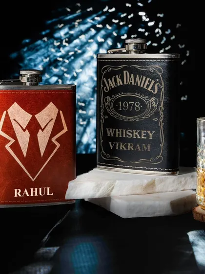 For a touch of class, I offer these personalized leather hip flasks. Available in black and brown, I can engrave any name, logo, or design, like the classic whiskey label or a sharp tuxedo graphic shown here.