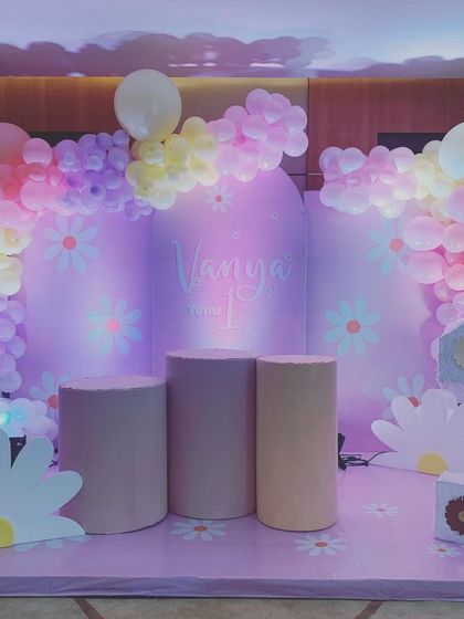 A sweet and simple Daisy theme for a first birthday. The pastel balloon arch and minimalist backdrop create a soft, dreamy atmosphere, with daisy props and a floral number '1' completing the look.