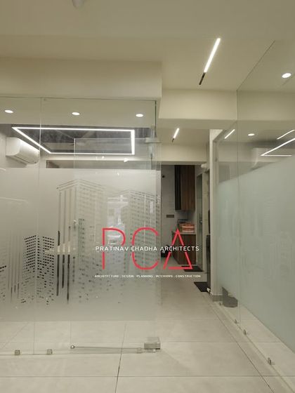Frosted glass partitions with a city skyline motif provide visual separation for workstations while allowing light to pass through.