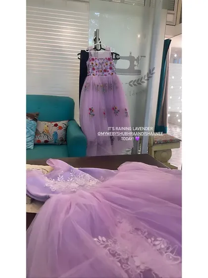 A peek into our studio at two lavender dresses in the making. One is a long tulle gown with floral embroidery, and the other is a more formal dress with white lace appliqué, showing our range in kids' occasion wear.
