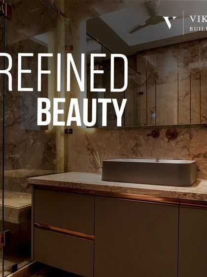 This image showcases refined beauty in a bathroom. The design features a mix of dark marble, a floating vanity with copper accents, and a sleek, modern vessel sink.
