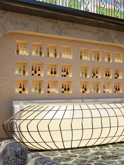 A close-up of the glowing bar and backlit bottle display. The design uses light and form to create a dramatic and sophisticated atmosphere, perfect for an evening out.