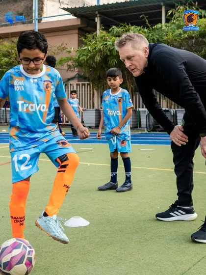 Observing and guiding. Heimir provides real time feedback to a young player, reinforcing the technical details that make a difference in a match.