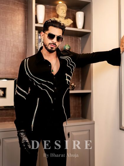 A confident pose that showcases the unique, flared cuffs and zipper details of this custom black shirt.