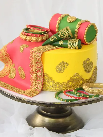 Celebrating traditional pre-wedding ceremonies like Haldi and Mehndi with a cake that is as vibrant as the occasion itself. This design incorporates intricate, edible henna patterns, rich colors, and details like fondant bangles and a draped dupatta.