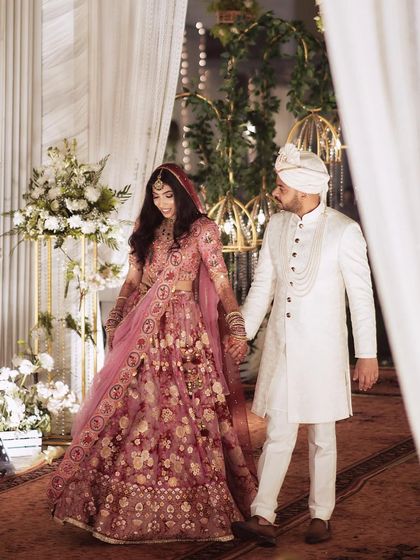 Pallavi and her groom make a beautiful couple. Her soft pink Gazal Gupta lehenga was paired with a romantic makeup look featuring soft waves in her hair.