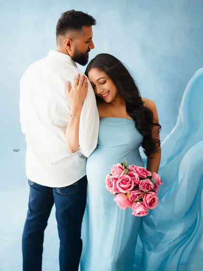 A tender moment against a dreamy blue backdrop. The partner's gentle touch and the mamma's happy smile make this a perfect shot.