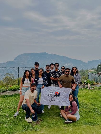Our group with the Bengaluru Trekkers banner, with the beautiful Kodaikanal hills in the background.