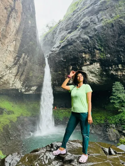A trekker posing at the stunning Devkund waterfall, a perfect picture of being wild, beautiful, and free in nature.
