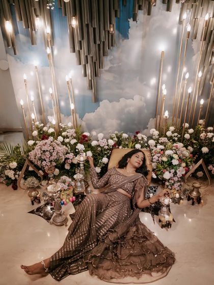 A dreamy Mehendi portrait. The bride is surrounded by flowers and candles, creating a magical and serene atmosphere.