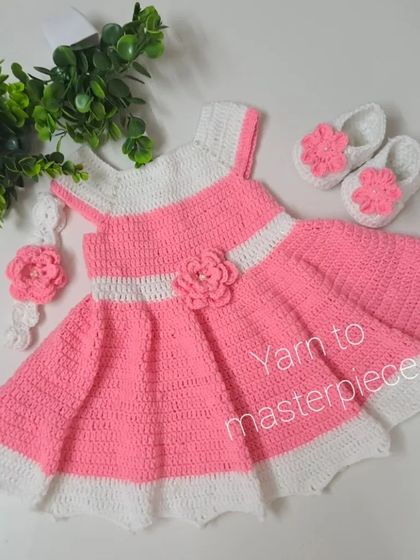 This pink and white crochet frock set is perfect for birthdays or parties. The full set includes the dress, a matching floral headband, and a pair of simple booties.