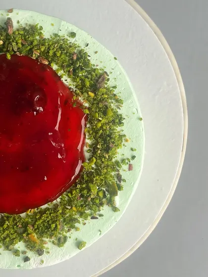 The vibrant top of my Raspberry Pistachio cake. I use a fresh raspberry compote and a sprinkle of crushed pistachios to create a beautiful contrast of colour and flavour.