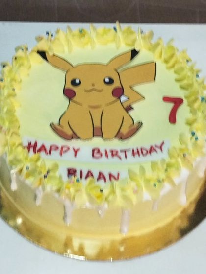 A simple and cute Pikachu cake. This design features the iconic Pokémon on a yellow-frosted cake with a white chocolate drip.