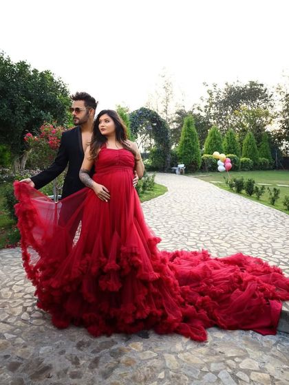 A full view of this gorgeous red ruffled gown. The long, flowing train adds drama and romance, making it a perfect choice for an outdoor garden or resort photoshoot.