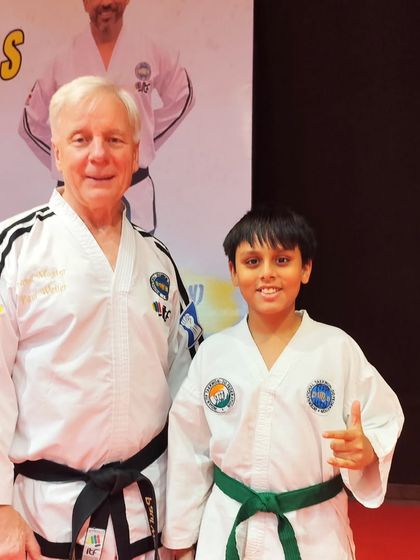 A young green belt student with Grandmaster Paul Weiler, a memory he will cherish for a lifetime.