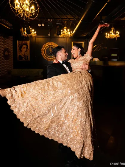 A fun and celebratory lift. This shot captures the joy and energy of the cocktail party, with the bride's gown beautifully displayed.