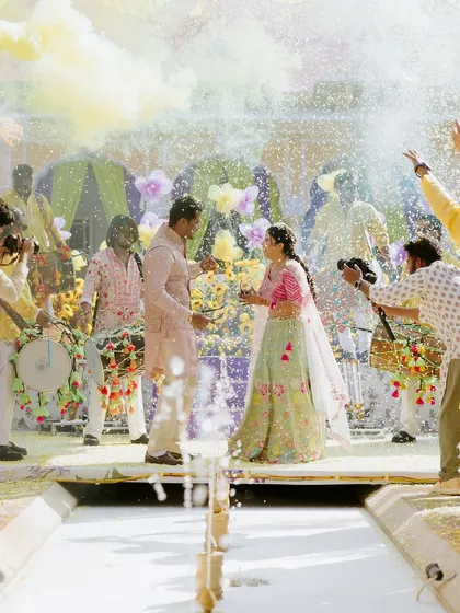 A moment of pure joy at a vibrant Haldi ceremony. We orchestrate multi-day celebrations where each event has its own distinct energy, capturing the couple's personality through custom decor, lively entertainment, and perfectly timed moments like this celebratory color splash.