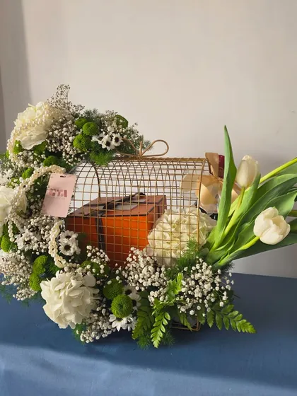Even the most luxurious gifts deserve a presentation that matches their grandeur. Here, I've created a stunning setting for an iconic orange box, nestled within a golden birdcage and surrounded by fresh white tulips, carnations, and baby's breath.