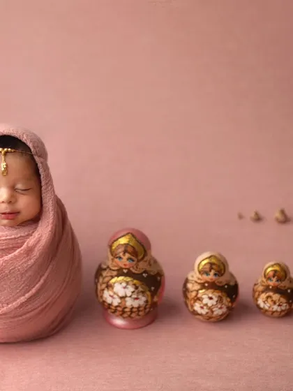 A unique and artistic concept featuring Russian nesting dolls. This shot plays with scale and color to create a truly memorable and creative portrait.