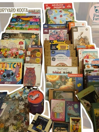 A mountain of puzzle boxes, showcasing the incredible variety available at our Jigsaw Jam events.