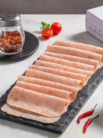 Slices of chicken salami elegantly arranged on a slate platter, with the Zappfresh product box visible in the background.