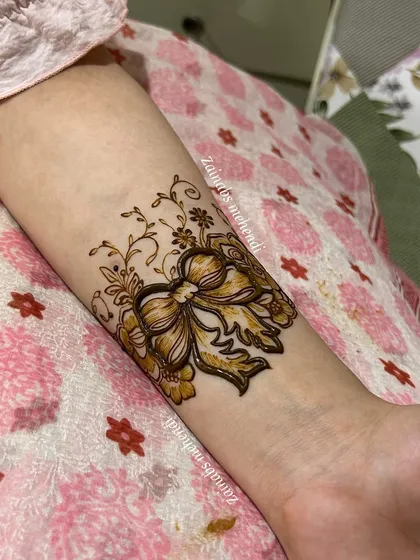 A playful and unique bow design for engagement bride Rida. This is a perfect example of how we can personalize your henna for any occasion.