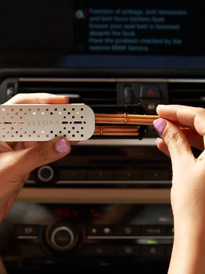 A close-up of our car fragrance vent clip in action. The metallic, minimalist design clips easily onto both vertical and horizontal air vents, discreetly adding a touch of luxury to your car's interior.