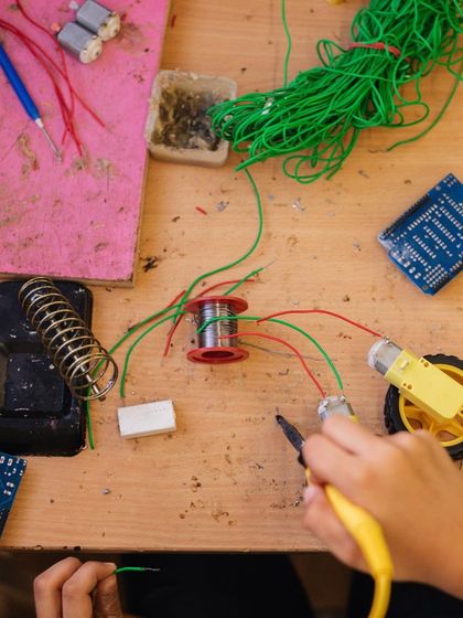 A bird's-eye view of a robotics workstation, complete with wires, motors, and circuit boards. This is the creative chaos where ideas become reality.