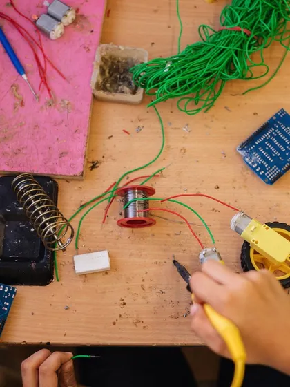 A bird's-eye view of a robotics workstation, complete with wires, motors, and circuit boards. This is the creative chaos where ideas become reality.